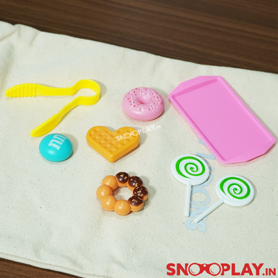 Baking doll set that has a baking tray and some toy treats like donuts, waffles and MnMs.