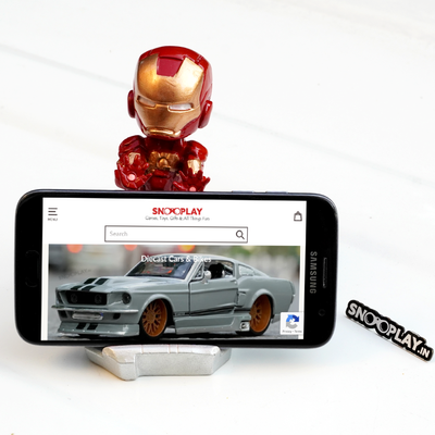 View of Iron man bobblehead action figure, holding a phone in its phone stand.