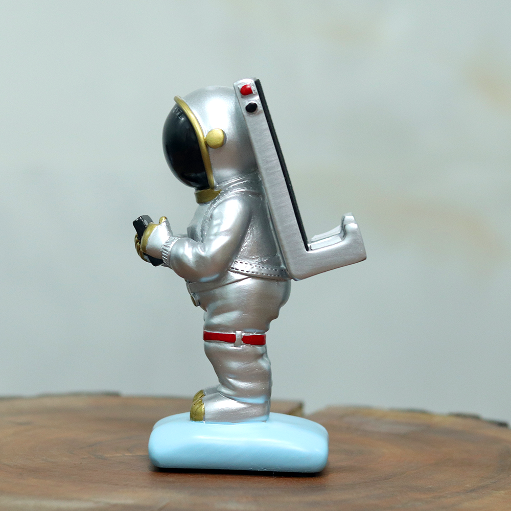 Side look of the silver coloured astronaut mobile phone stand with black detailing.