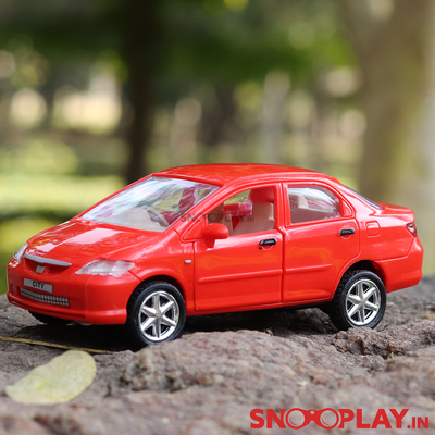 Brighly red coloured honda city toy car, with opening doors and pull back feature.
